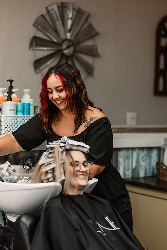 stylist emily alexander applying hair color for a client