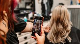 elegant stylist setting, serene expression, sketching designs, photorealistic, stylish boutique with mannequins and draped fabrics, highly detailed, mannequins subtly reflecting light, balanced composition, rich jewel tones, focused spotlight lighting, shot with an 85mm prime lens.