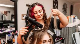 rustic stylist scene, reflective expression, sipping a cup of tea, photorealistic, quaint cafe with brick walls and wooden tables, highly detailed, steam rising from the cup, sharp focus on foreground, warm earthy tones, dappled afternoon lighting, shot with a 35mm prime lens.